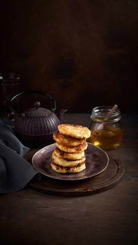 Russian fried quark pancakes with raw golden honey and tea
