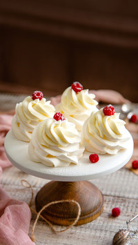 Homemade white mini desserts pavlova on wooden cake