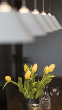 Yellow dandelions in a vase and an open book on the table