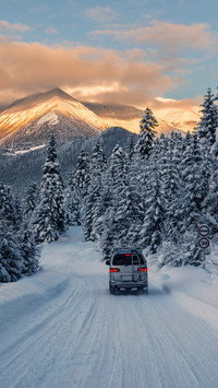 The car is riding on the powder snow road mountains