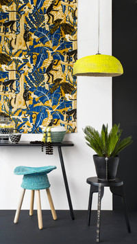Ethnic stool below console table and african wall hanging