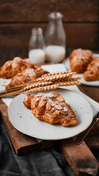 Almond croissant with custard filling on wood background