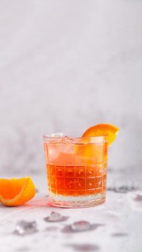 Fresh ice tea summer cocktail with orange and ice in glass