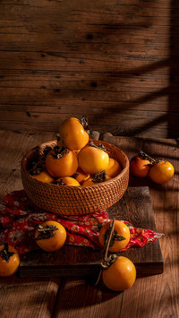 Persimmons on the plate are on the table