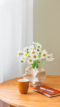 A bouquet of daisies in a ceramic vase