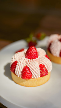 Close up strawberry tarts with cream sauce