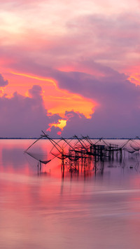 Local fishing nets in a lake with fisherman in sunrise