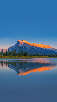 Rundle Mountain reflecting in Two Jack Lake at sunrise