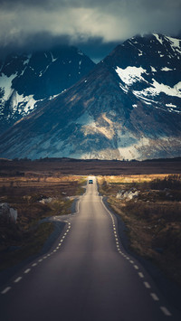 The Car is Driving on The Road at The Foot of The Mountain