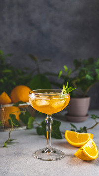 Champagne Coupe Glass of Refreshing Orange Cocktail with Ice