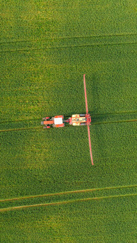 Aerial view of harvest fields with tractor in Poland