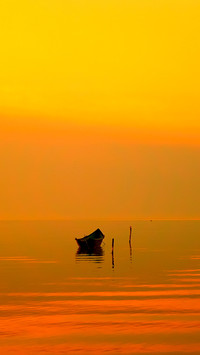Beautiful sunset over water and silhouette fishing boat