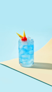 Glass of Blue Lagoon cocktail on color background