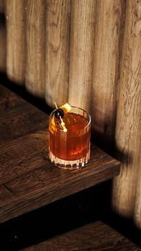 A cocktail with ice and a toothpick with olives