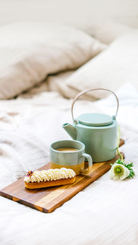 Breakfast tray in morning light standing on comfort bed