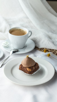 Side view of chocolate cake and coffee on white table