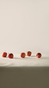 Organic red apple lying on white linen tablecloth