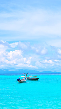 Longtail motor boat moored in blue tropical waters, thailand