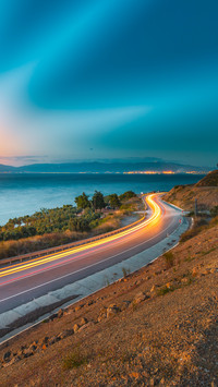 Car lights and coastal path at sea shore