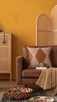 The warm living room interior features a rattan sideboard
