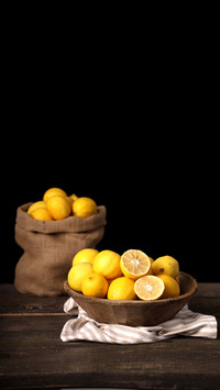 Yellow lemons in wooden plate