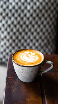 Two Cups of hot cappuccino on wooden desk with spoons