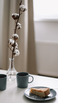 Piece of apple pie on plate and cup of coffee on white table