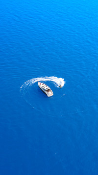 Water scooter movement close to the yacht aerial view