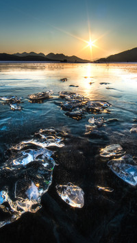 The frozen lake mirrors the snow silently.