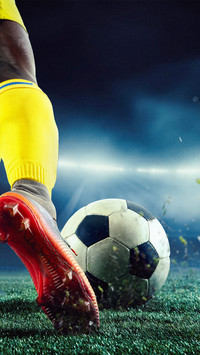 Football player in yellow uniform on arena playing