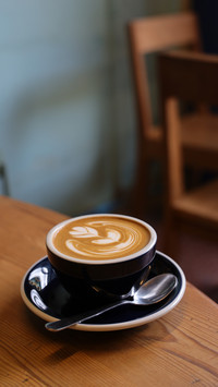 Latte art on wood desk in vintage coffee shop