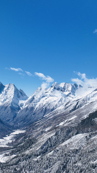Snow capped mountains clouds reflecting the vast sky