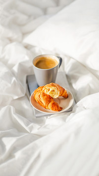 cup of coffee and book in bed at home