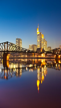 Skyline and bridge reflected in main river at dusk