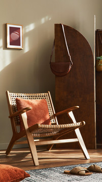 living room with rattan chair, wooden screen, pillows
