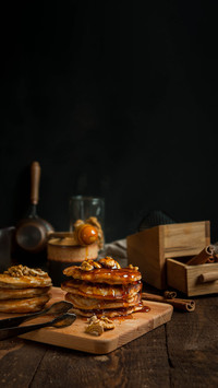 Pancakes topped with maple syrup and sprinkled with walnuts