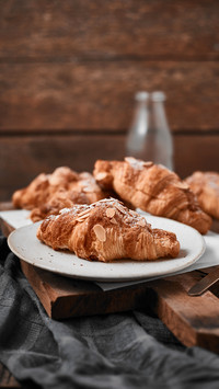 Almond croissant with custard filling on wood background