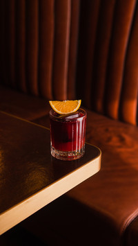 Cocktail with slice of orange in glass on the table