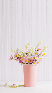 spring flowers in vase on white wooden background