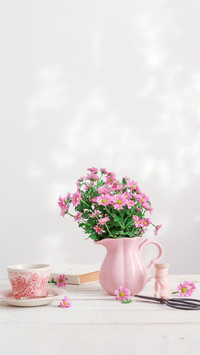 Pink chrysanthemum flowers in a pink pitcher on a table