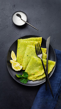 Crepes of Spinach with Yoghurt Sauce on Black Concrete
