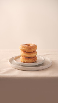 Stack of homemade baked donuts sitting on white plate