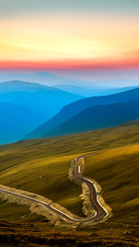 Layers of haze cover the mountains peaks at sunset