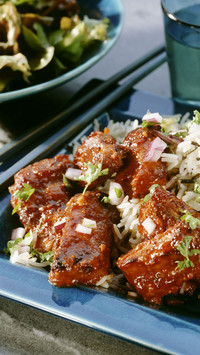 Spicy spare ribs with rice on a shallow blue plate
