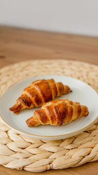 Croissants on a white plate on a wooden background