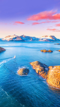 Aerial view of fishing boats, rocks in the blue sea