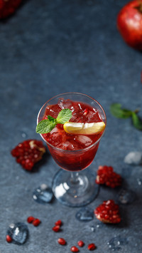 Pomegranate refreshing summer cocktail on dark