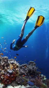 Freediver Gliding Underwater over Vivid Coral Reef