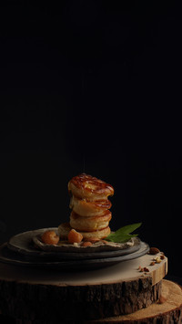 Pancakes with nuts and honey on a black background
