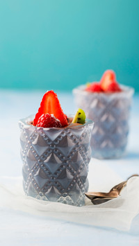 Glasses of mousse au chocolat garnished with raspberries